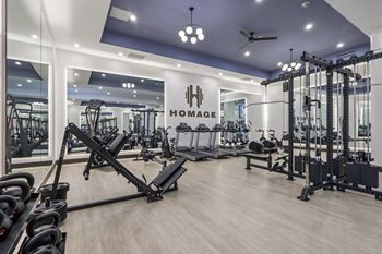 A gym with a variety of equipment including weights and cardio machines at LiveWell Apartments, Pennsylvania